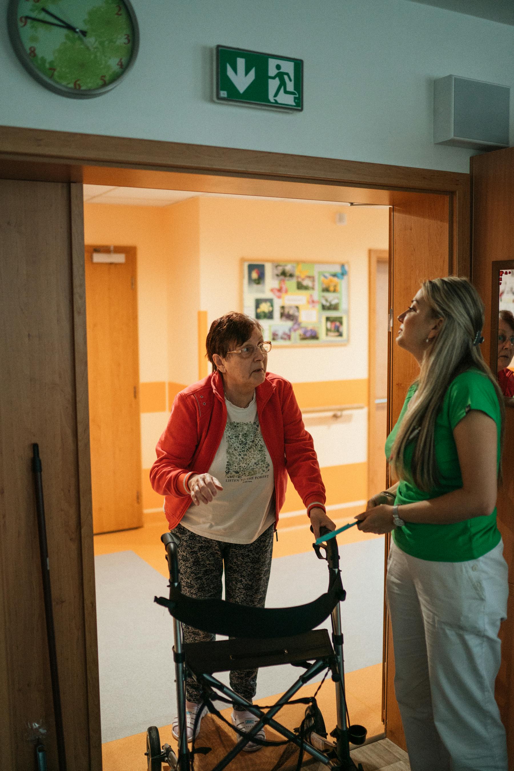 Senior patient using a walker with therapist support in a care setting